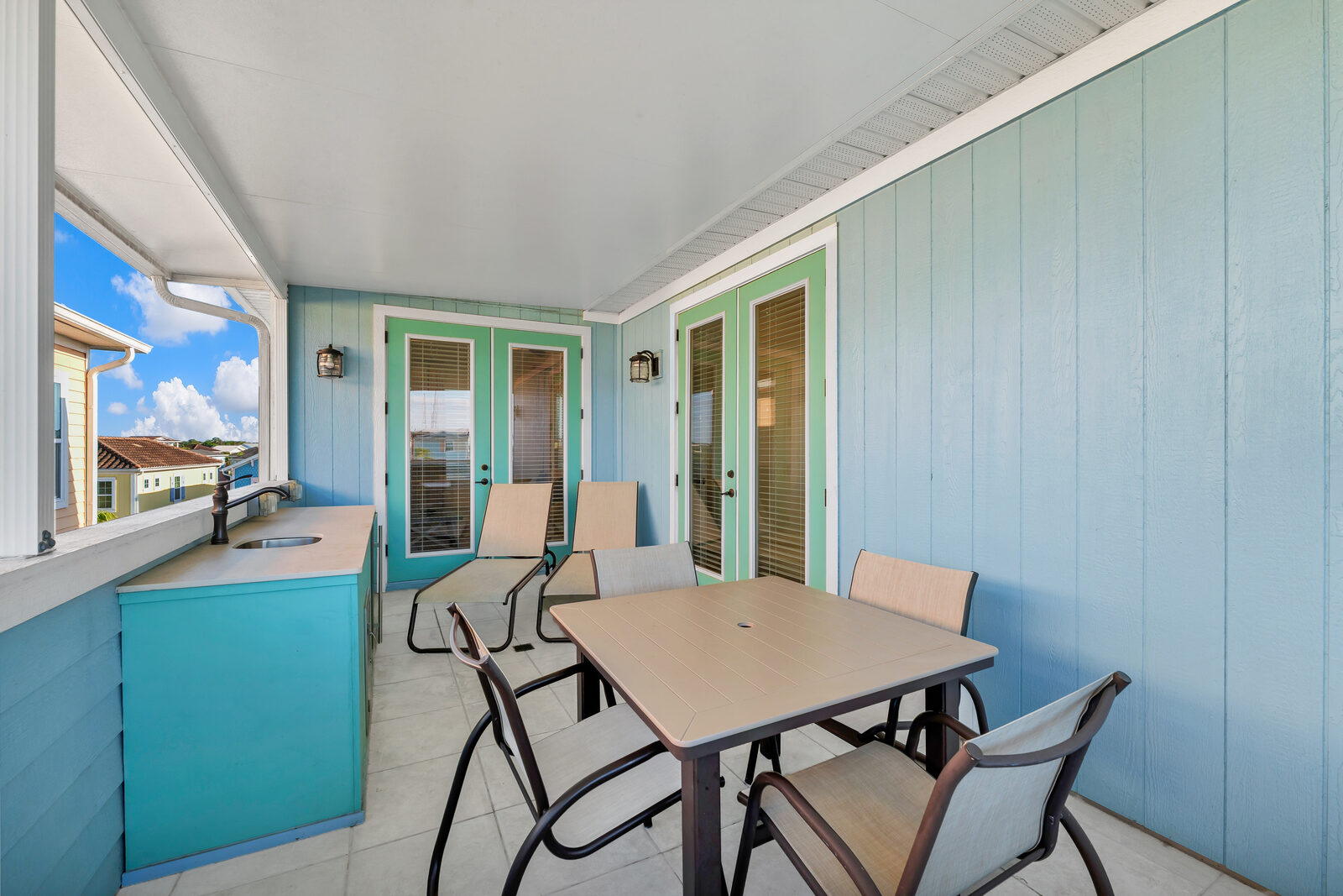 Covered terrace with dining table and wet bar
